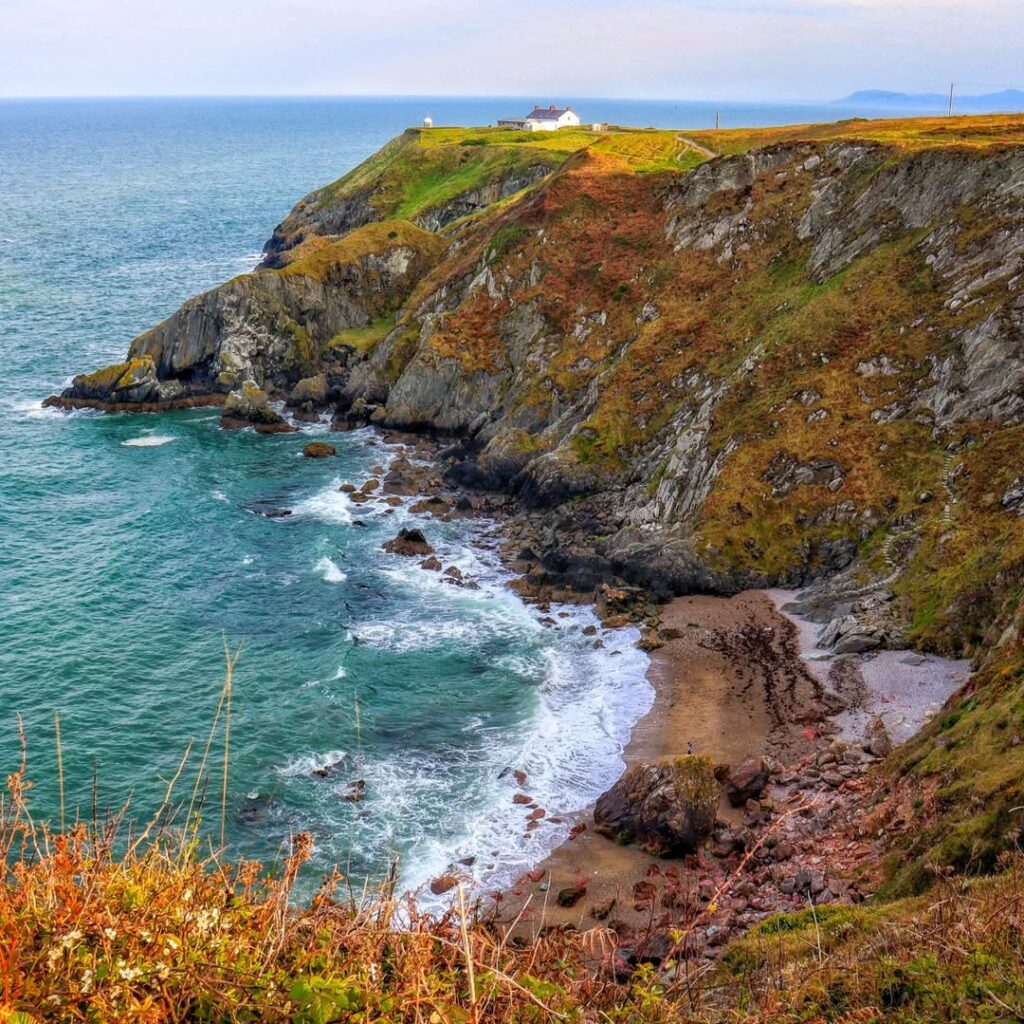 Breathtaking view from Howth Summit, showcasing lush green cliffs, rugged rocky shores, and crystal-clear waters one of the best things to do in howth.