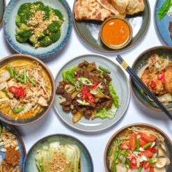Spicy Stir-Fried Beef, Chicken Curry Noodles, Grilled Fish, Steamed Broccoli, Fried Rice, and Fresh Veggies with Peanut Sauce at Kampong Ah Lee.