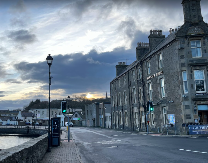 Street view of Mackay's Hotel in Wick with a cloudy evening sky.